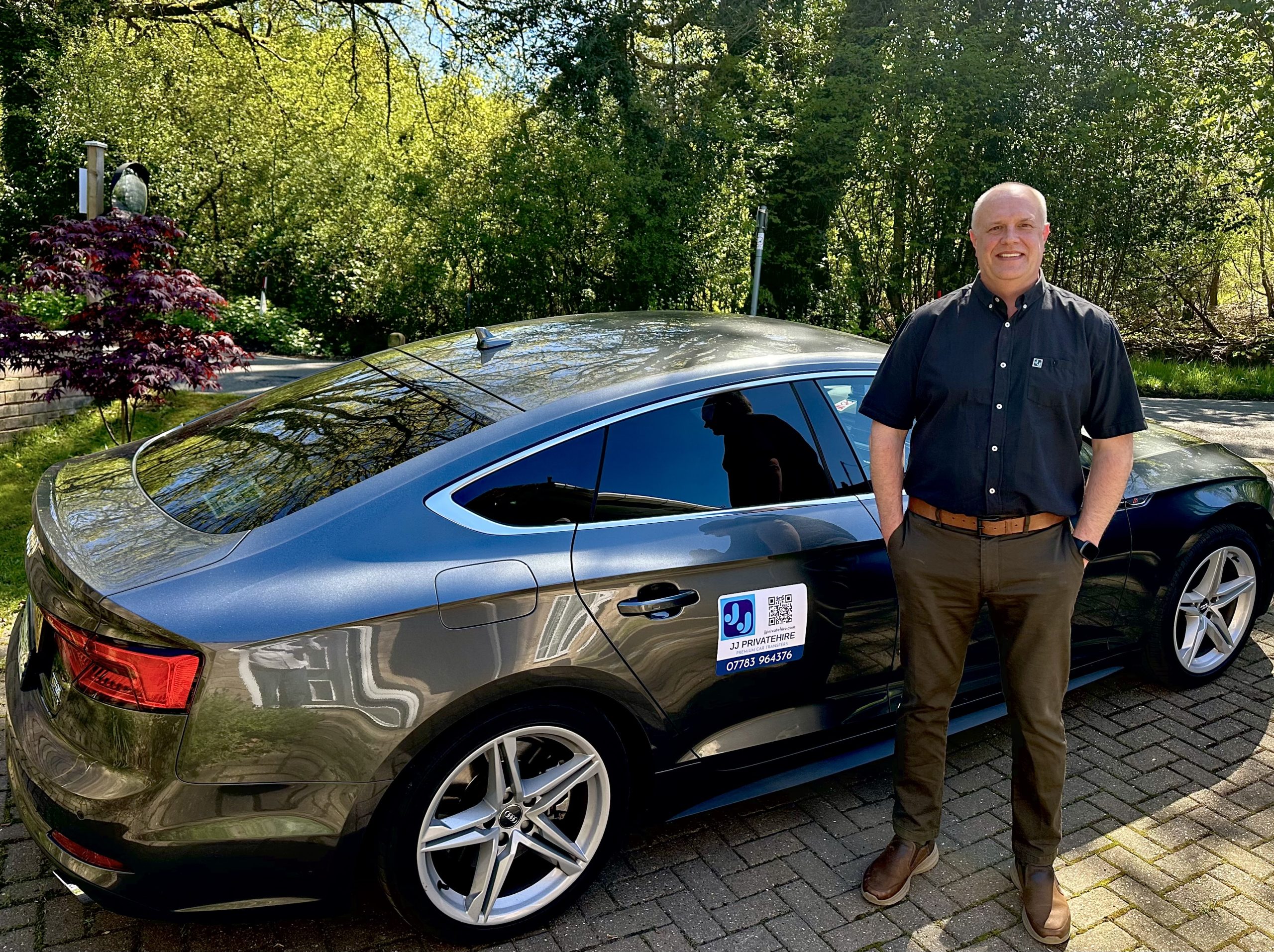 Jason from JJ Private Hire standing beside his private hire car in West Berkshire